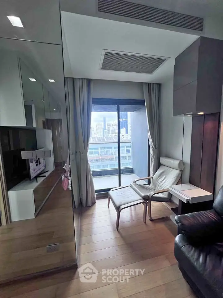 Modern living room with city view, featuring sleek furniture and floor-to-ceiling windows.