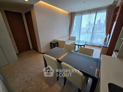 Modern living room with city view, featuring elegant furniture and large windows for natural light.