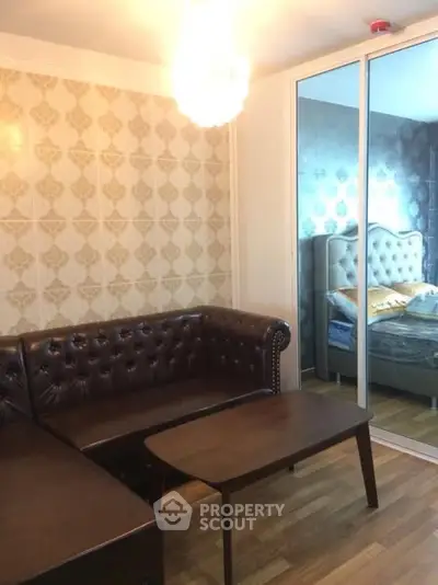 Stylish living room with leather sofa and mirrored closet in modern apartment.