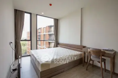 Modern bedroom with large windows and stylish furniture in a contemporary apartment.