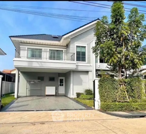 Modern two-story house with spacious driveway and lush greenery