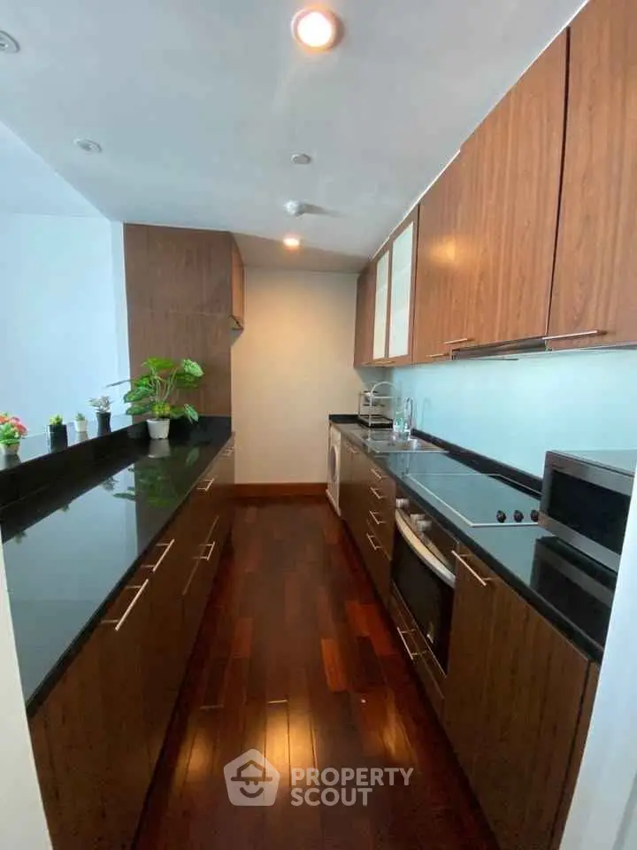 Modern kitchen with sleek wooden cabinets and dark countertops