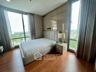 Spacious bedroom with panoramic windows offering stunning views and modern decor.