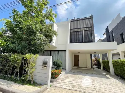 Modern two-story house with sleek design and spacious driveway in a serene neighborhood.