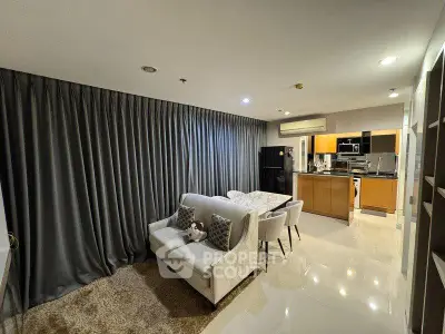 Modern open-plan living room with cozy seating and sleek kitchen design
