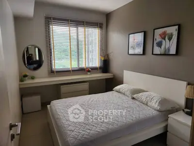 Cozy bedroom with modern decor and large window for natural light.