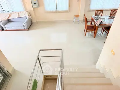 Spacious living area with modern dining set and cozy sofa, perfect for family gatherings.