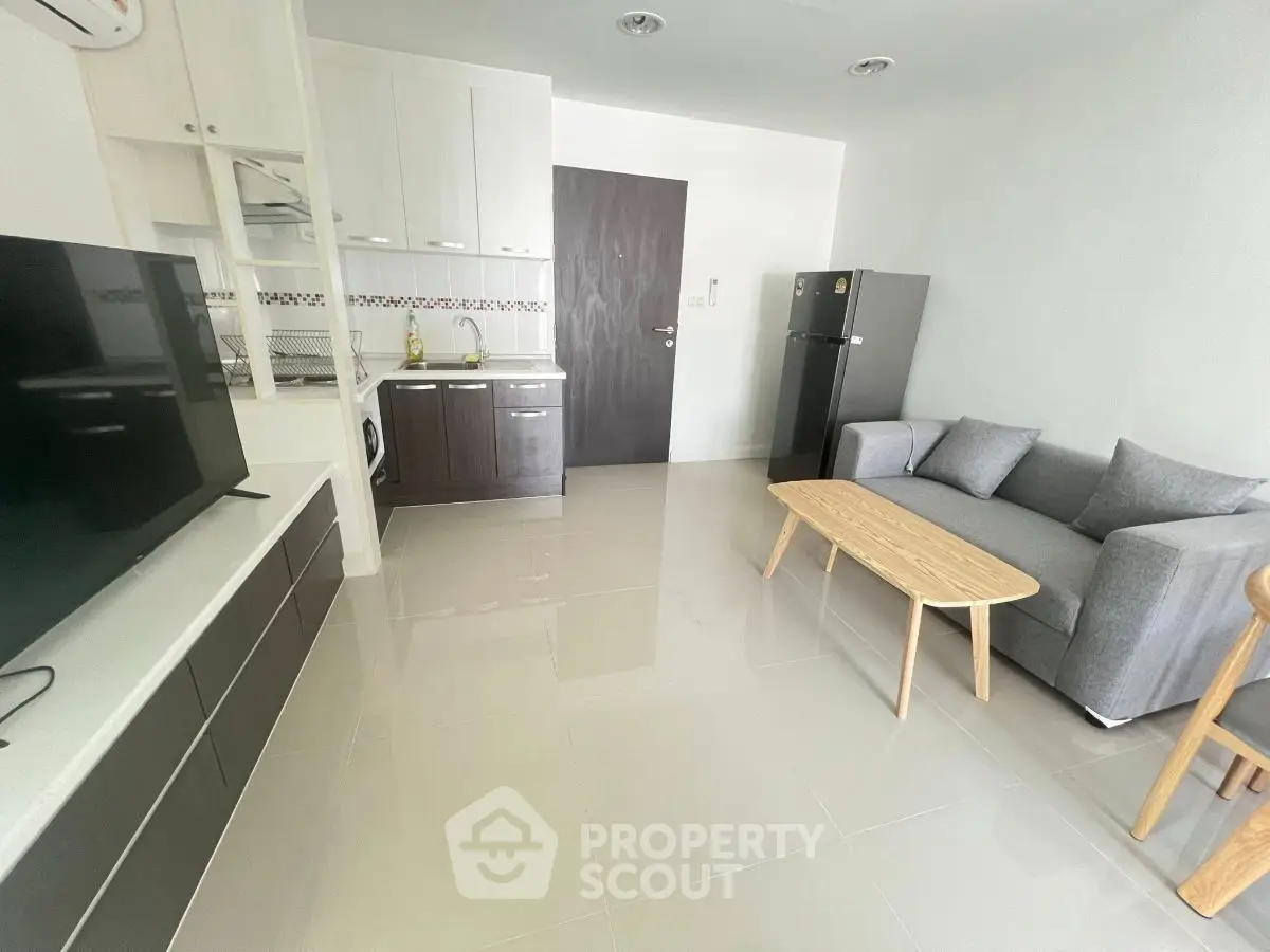 Modern living room with sleek furniture and compact kitchen area