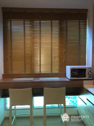 Cozy kitchen nook with wooden blinds and microwave