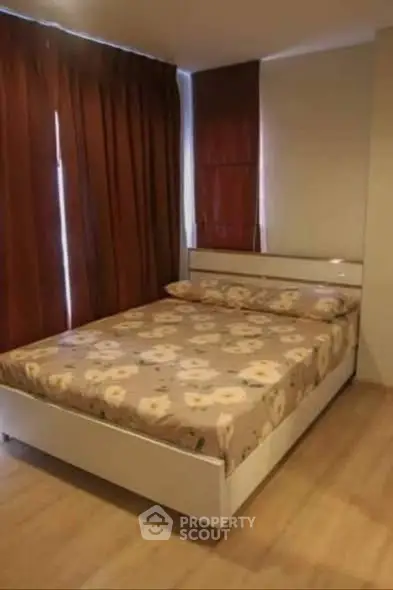 Cozy bedroom with floral bedding and warm lighting, perfect for relaxation.