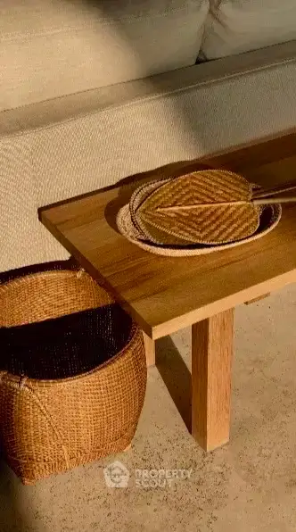 Stylish living room with wooden table and wicker basket, perfect for modern interiors.