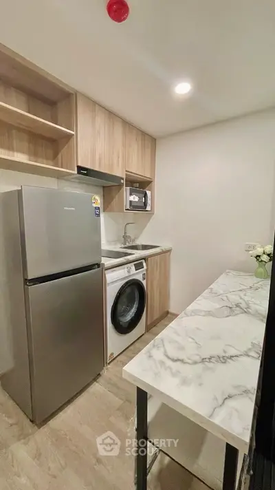 Modern compact kitchen with marble countertop and integrated appliances