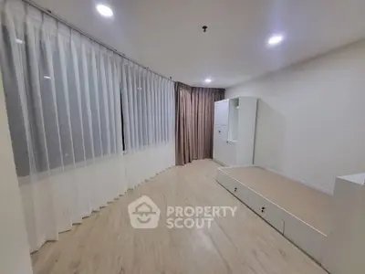 Spacious bedroom with elegant curtains and modern flooring