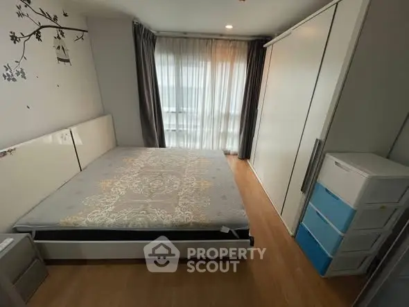 Spacious bedroom with modern decor and ample natural light, featuring a large bed and built-in wardrobe.