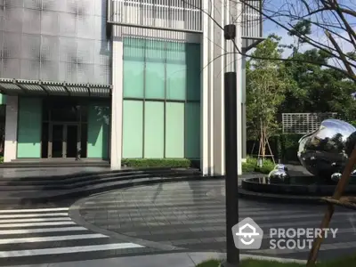 Modern building entrance with sleek design and reflective sculptures