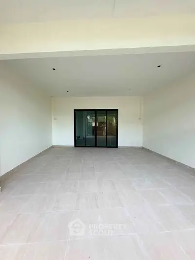 Spacious covered patio with sliding glass doors leading to the interior, perfect for outdoor gatherings.