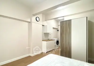 Modern studio apartment with compact kitchen and washing machine