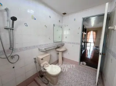 Spacious bathroom with shower and toilet in a well-lit apartment