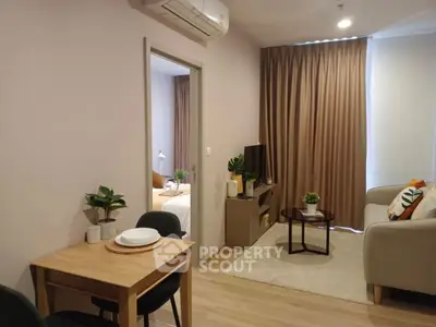 Cozy modern living room with dining area and bedroom view, featuring stylish decor and natural light.