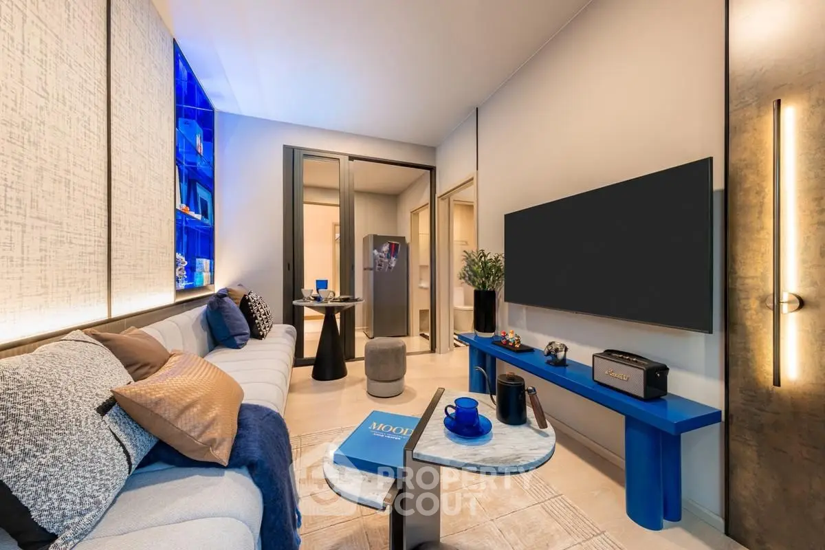 Modern living room with stylish decor and open layout, featuring a cozy sofa and sleek entertainment setup.