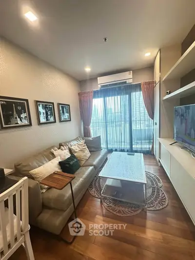Modern living room with cozy sofa, stylish decor, and large window offering city views.