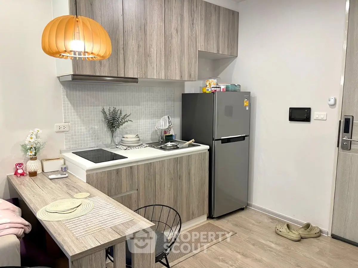 Modern compact kitchen with wooden cabinetry and cozy dining area.