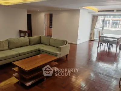 Spacious living room with wooden floors and large windows in a modern apartment