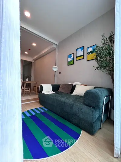 Stylish living room with modern decor and vibrant rug in a cozy apartment setting.