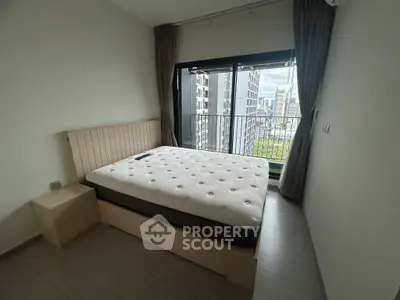 Modern bedroom with city view and large window, featuring a comfortable bed and sleek design.