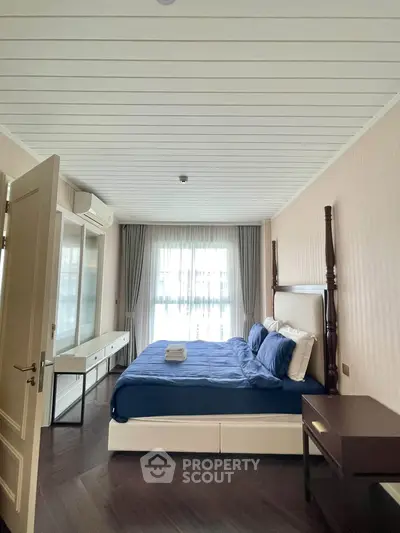 Spacious bedroom with elegant decor and natural light, featuring a comfortable bed and stylish furnishings.