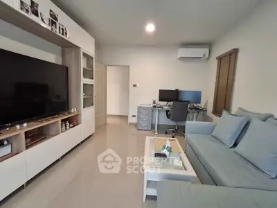 Modern living room with sleek furniture and dual monitor setup