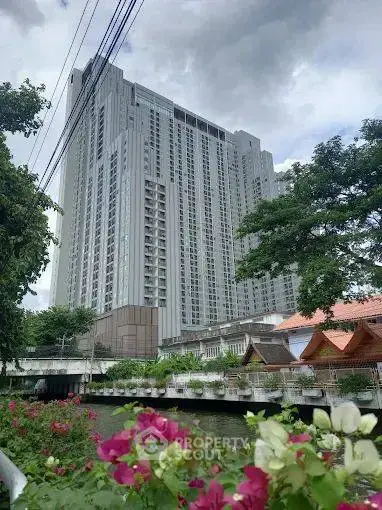 Stunning high-rise building with lush greenery and vibrant flowers, offering urban living with scenic views.