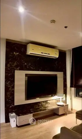 Modern living room with wall-mounted TV and air conditioning unit, featuring stylish decor and ambient lighting.