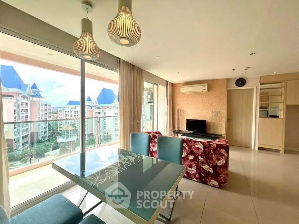 Spacious living room with modern decor and large balcony offering stunning views of the cityscape.