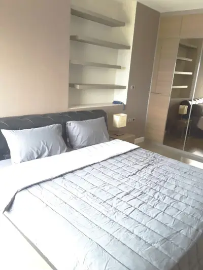 Modern bedroom with sleek design, featuring built-in shelves and mirrored wardrobe.