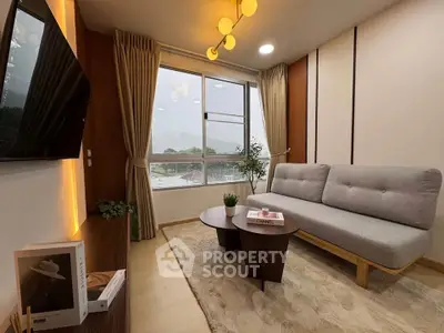 Modern living room with stylish sofa, wooden coffee table, and large window offering natural light.