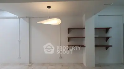 Minimalist interior with modern lighting and wooden shelves, perfect for a stylish living space.