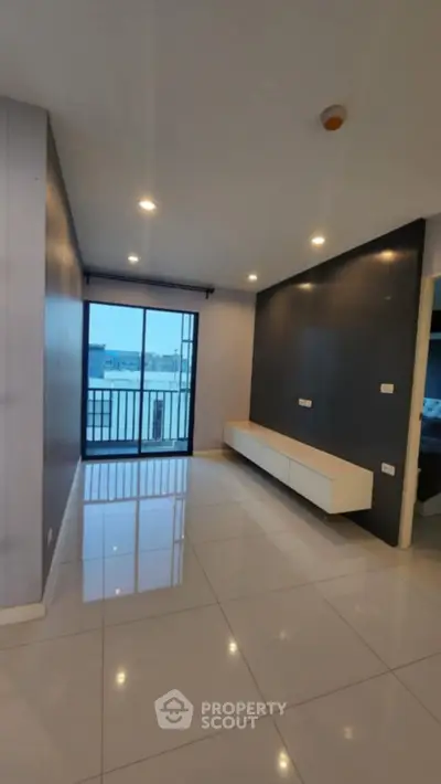 Modern living room with sleek design and balcony access in urban apartment