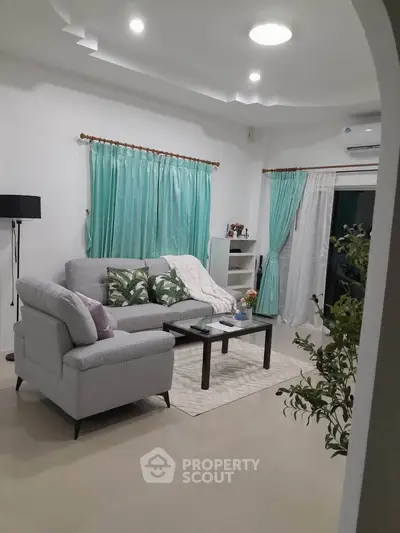 Charming living room with modern decor, cozy seating, and elegant curtains, perfect for relaxation and entertaining.