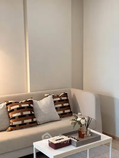 Stylish living room with modern sofa and decorative pillows, perfect for cozy relaxation.