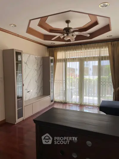 Spacious living room with elegant ceiling design and large windows for natural light.