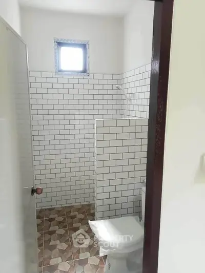Minimalist bathroom with white subway tiles and small window
