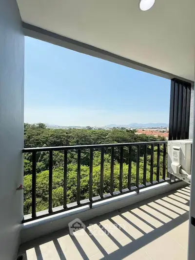 Stunning balcony view overlooking lush greenery and distant mountains, perfect for relaxation.