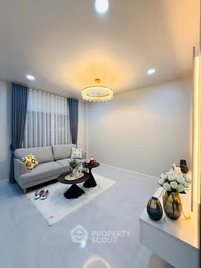 Modern living room with elegant chandelier and cozy sofa setup