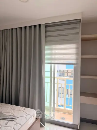 Modern bedroom with balcony access and stylish curtains in a contemporary apartment.