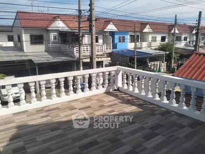 Spacious balcony with tiled flooring overlooking charming row houses in a suburban neighborhood.