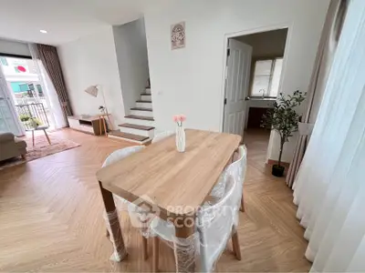 Modern open-plan living and dining area with stylish wooden flooring and natural light.
