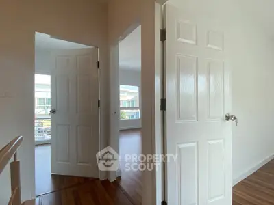 Bright hallway with wooden flooring and white doors in modern home