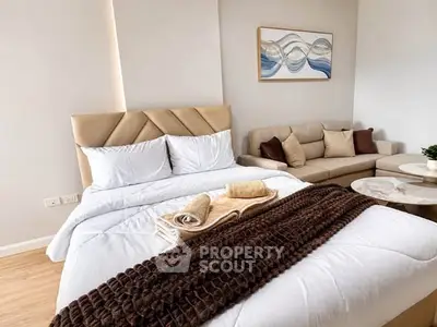 Luxurious bedroom with elegant decor and cozy seating area in modern apartment.