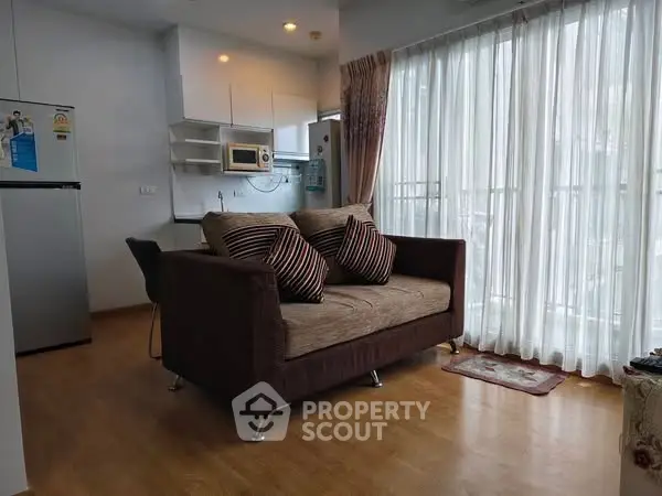 Cozy living room with modern kitchen and large windows in a stylish apartment.